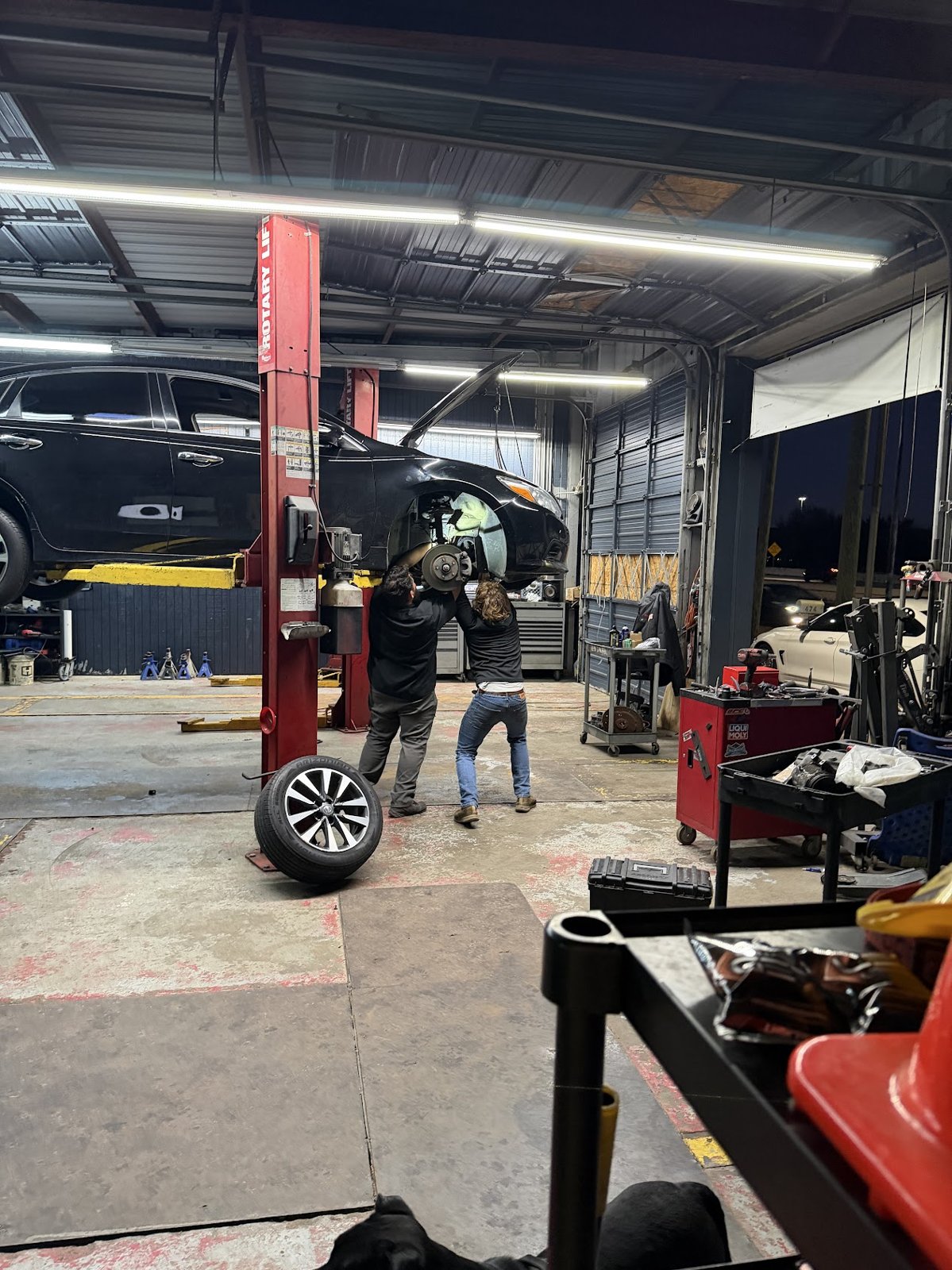 Car Time Automotive technicians working under a vehicle on the lift